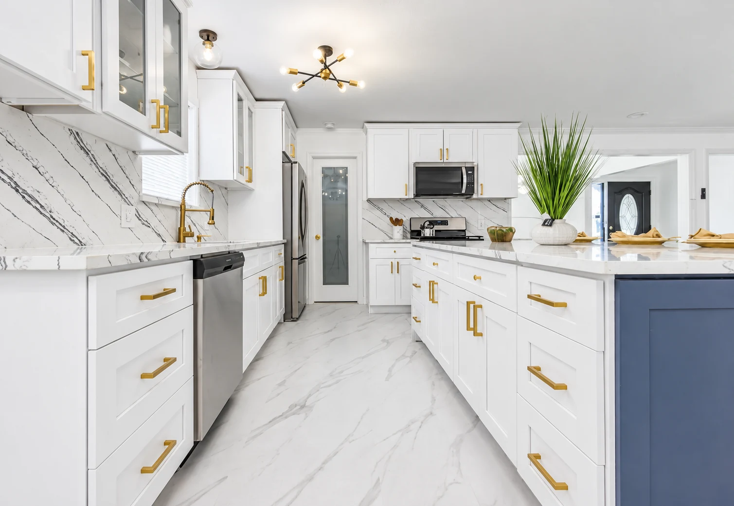 White shaker cabinets with gold hardware and a contrasting navy island — another view