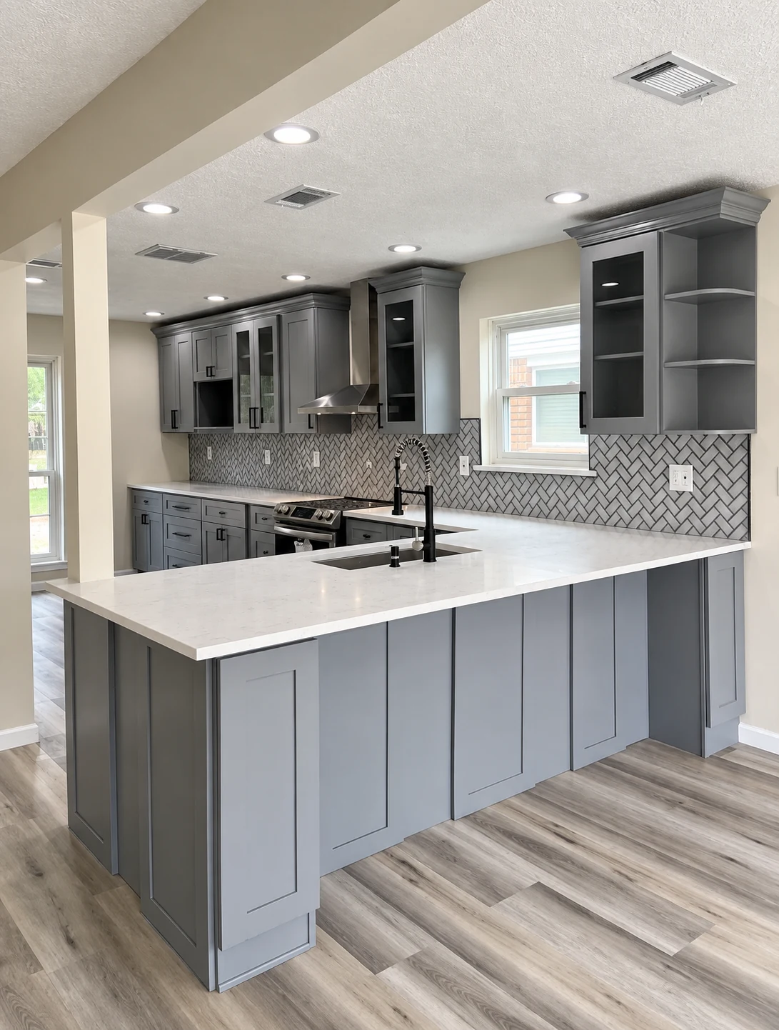 Gray shaker cabinets with dark hardware, glass-front uppers and a patterned backsplash — another view