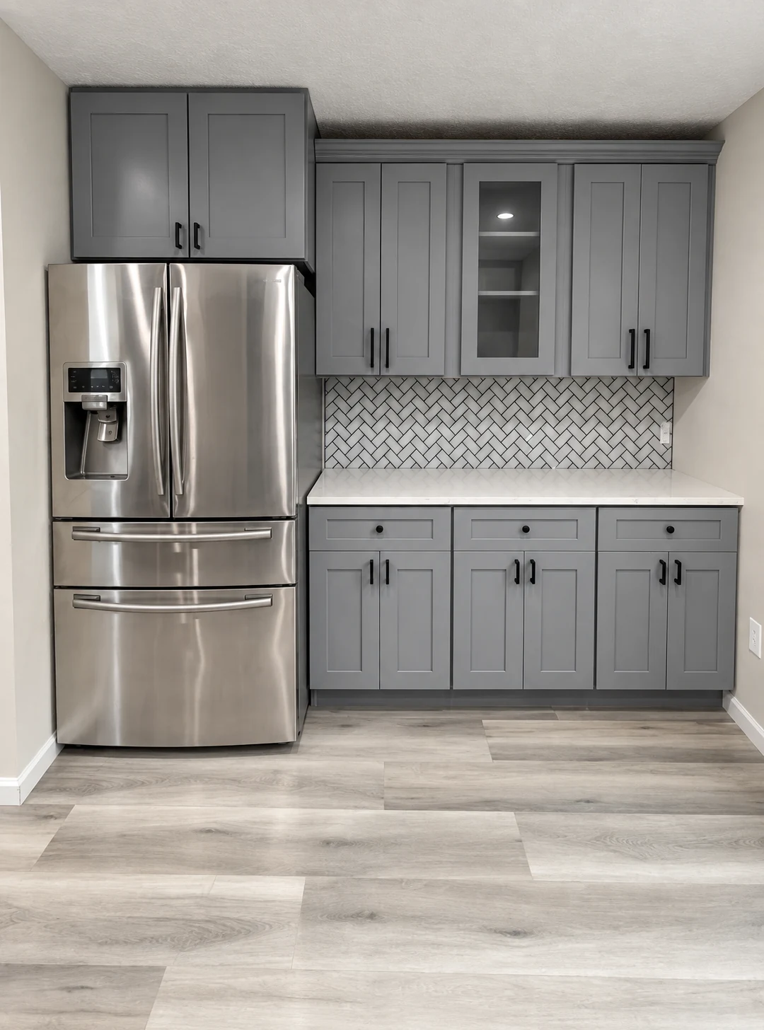 Gray shaker cabinets with dark hardware, glass-front uppers and a patterned backsplash — another view
