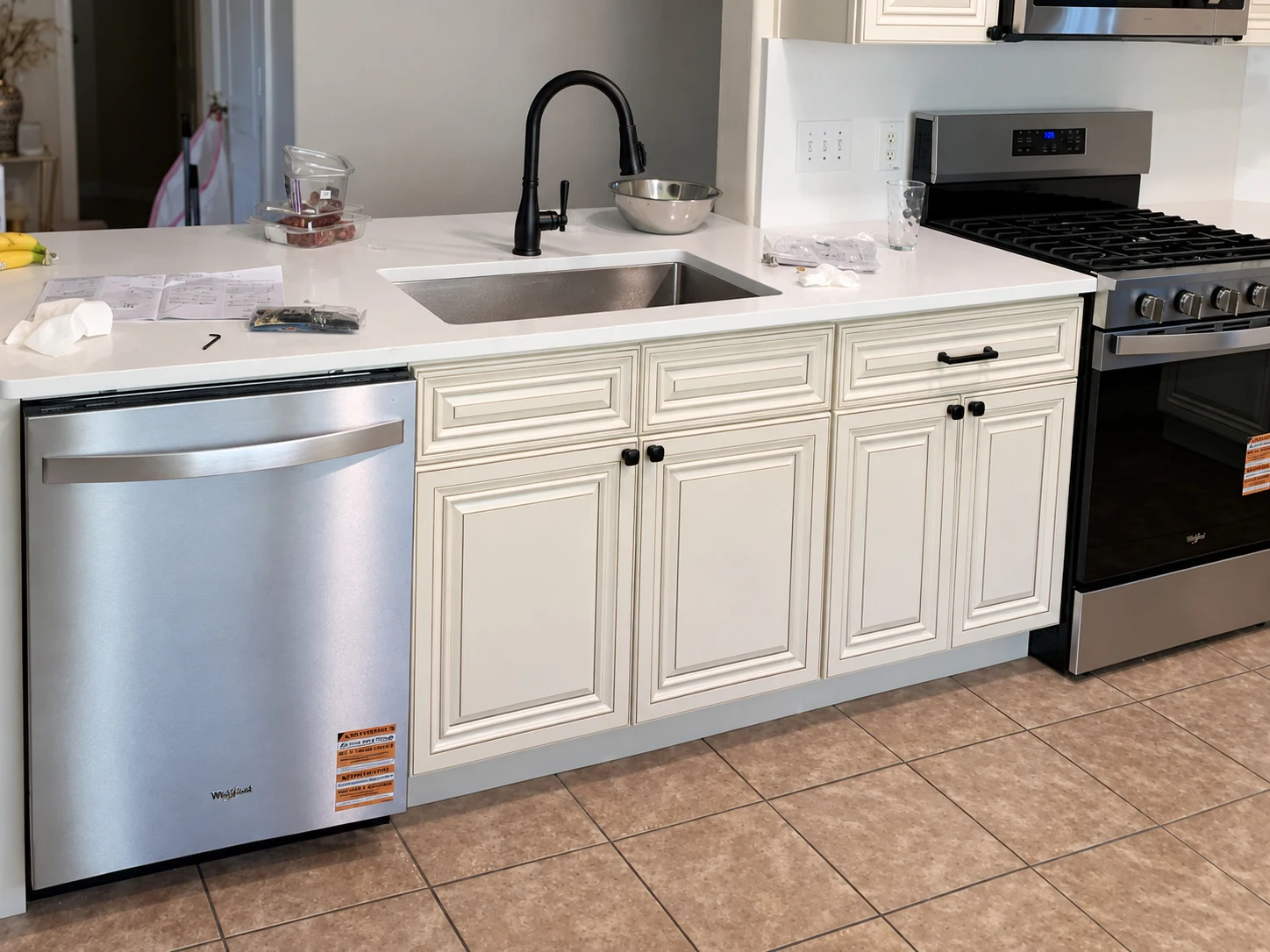 White raised-panel cabinet doors with dark knobs and a black faucet